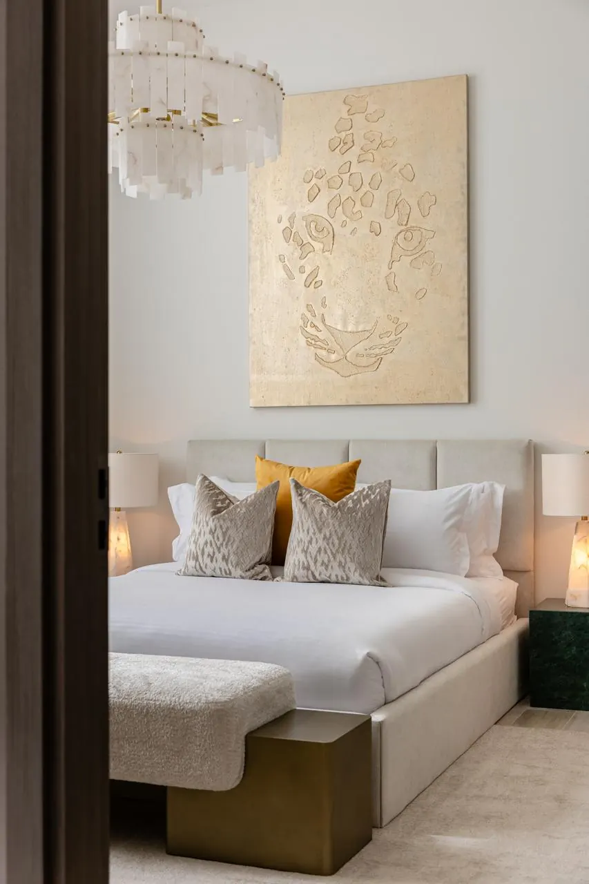 Bedroom with upholstered bed, patterned cushions and ochre accent pillow