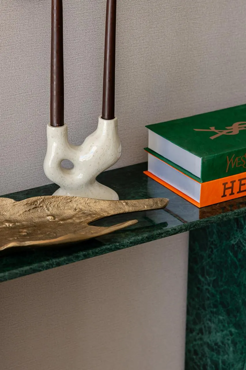 Green marble console styled with sculpture and books
