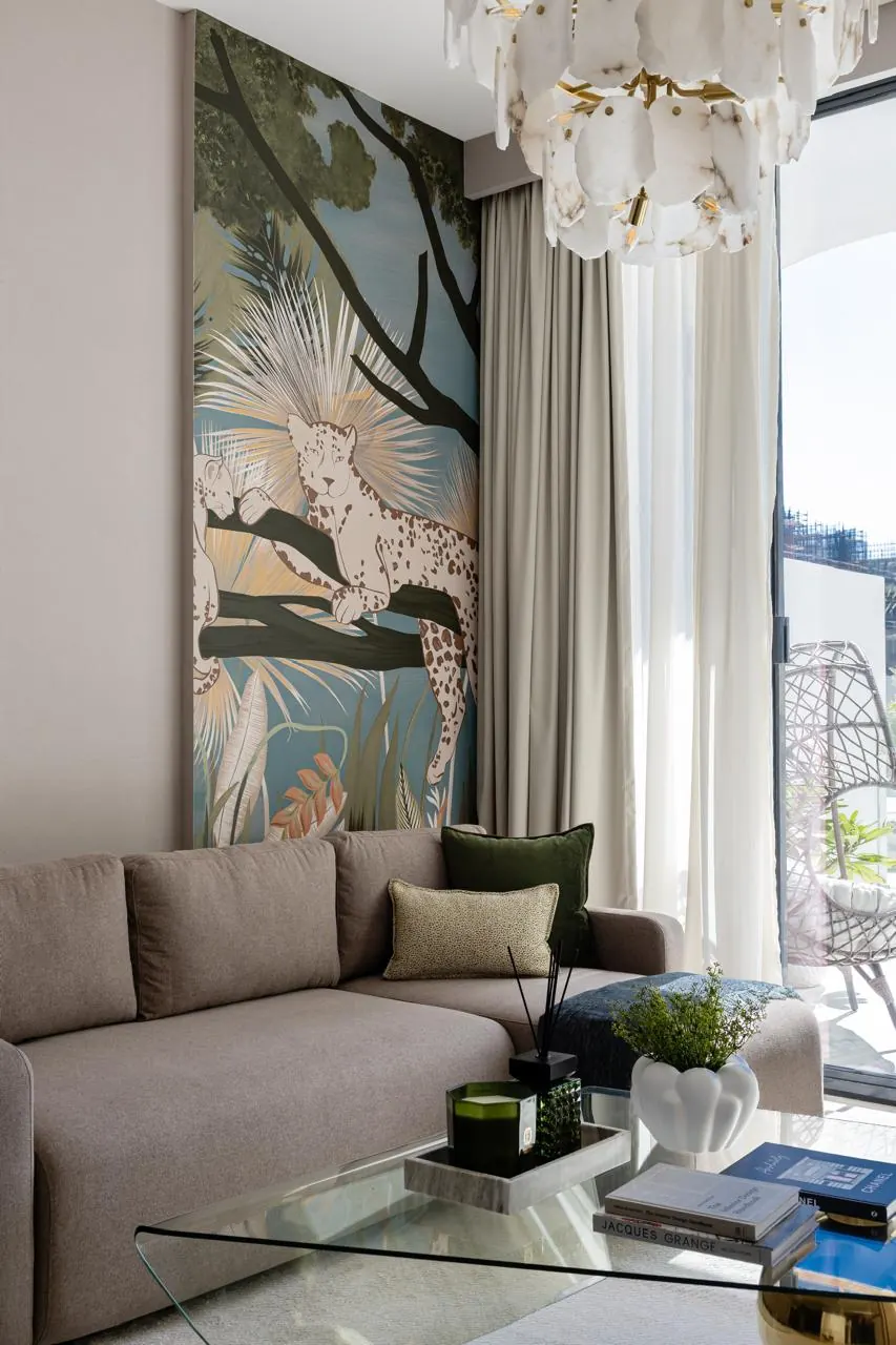 Living room with alabaster chandelier, botanical wall panel and sheer curtains